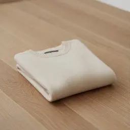 A cream cashmere-blend knit sweater paired with wide-leg wool trousers creates a refined, cozy silhouette. Tuck the sweater loosely for an effortless vibe.