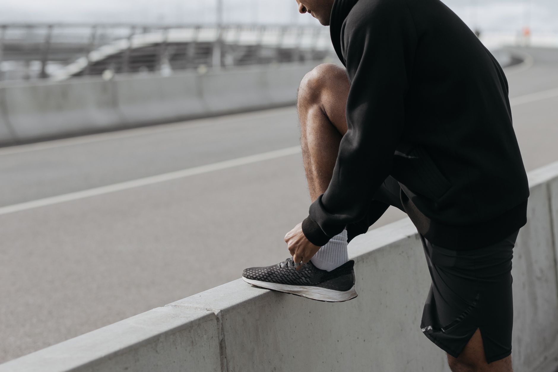 A person tying their running shoes with focus, symbolizing the start of a workout.
