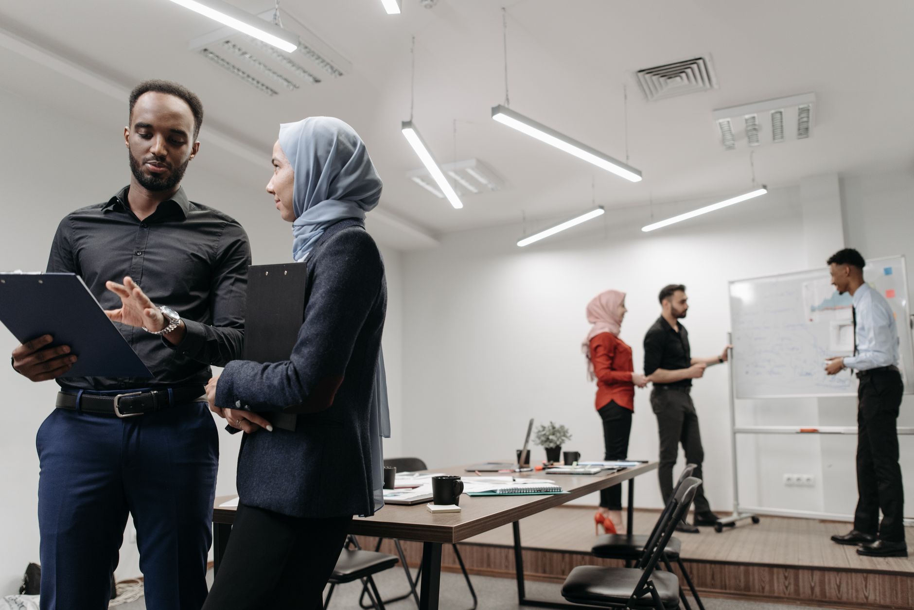 A diverse group of people in a collaborative work environment, one person confidently speaking up in a meeting.